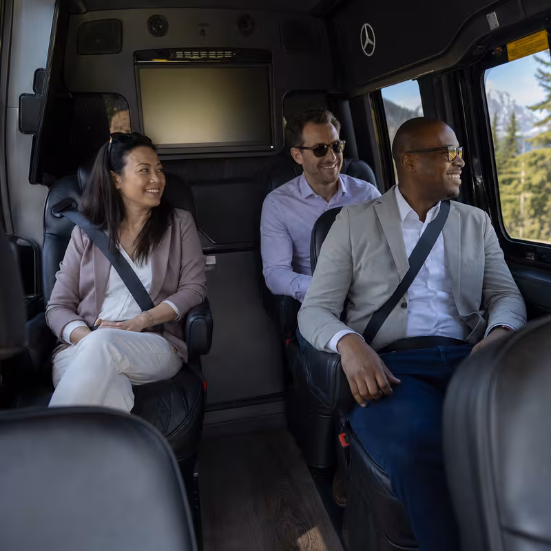 Group boarding a white charter bus for Corporate Transportation transportation in St Paul