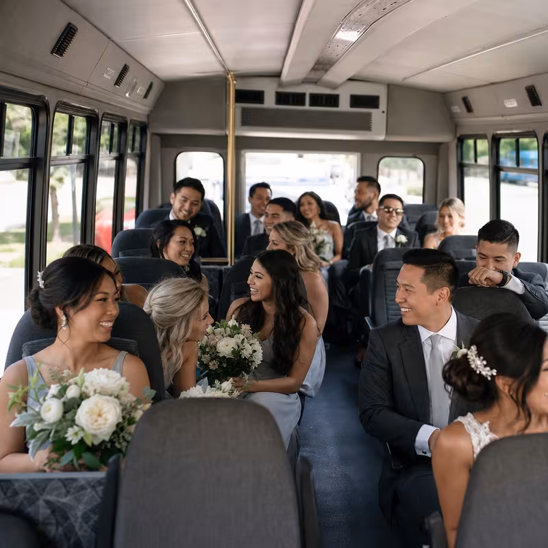 Group boarding a white charter bus for Wedding Transportation transportation in St Paul